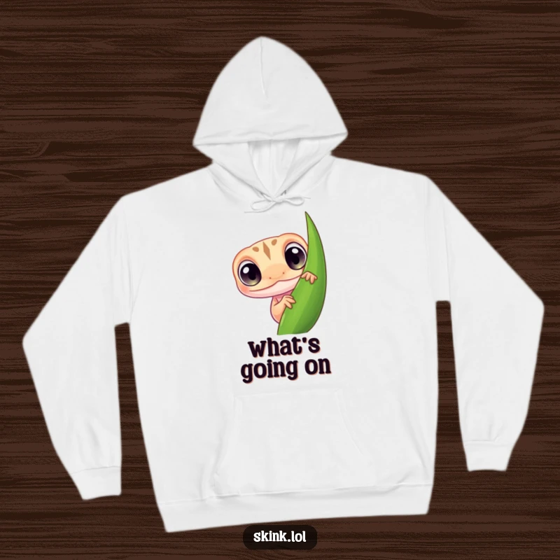 Funny skink hoodie, a tiny creature with large, curious eyes, peeking from behind foliage, warm and funny.