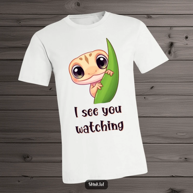 Funny skink t-shirt, tiny reptile with big curious eyes, peeking from behind a leaf, a humorous design.